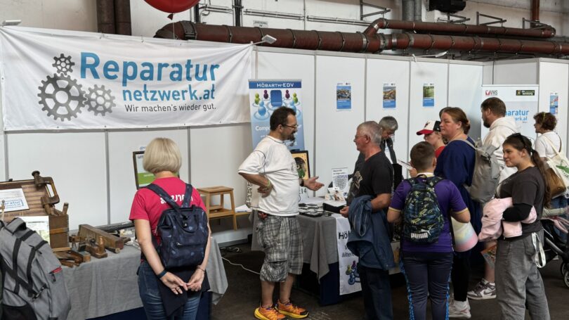 Besucher*innen beim Stand des Reparaturnetzwerkes beim Mistfest